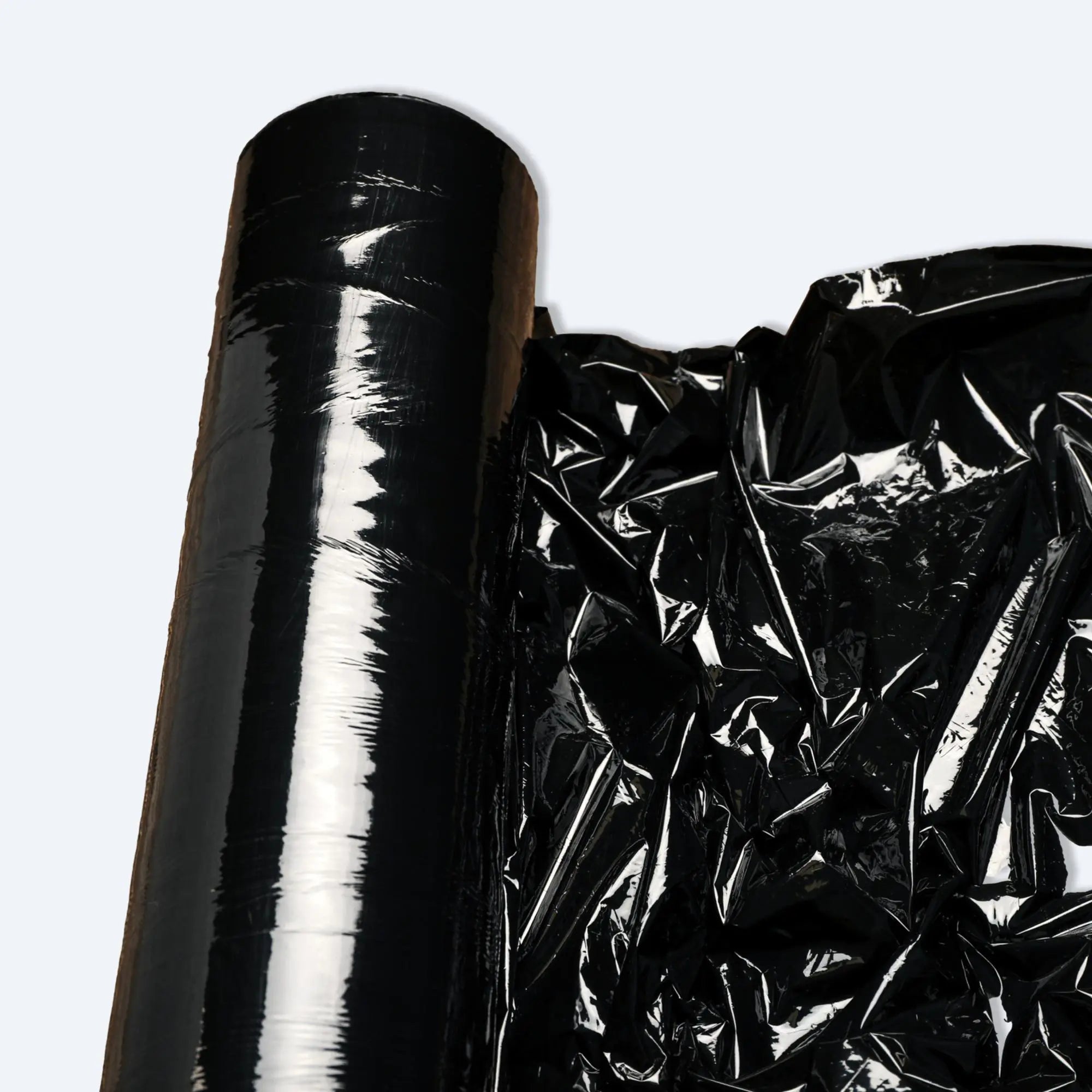 Glossy black stretch film roll partially unrolled with crinkled sheet.