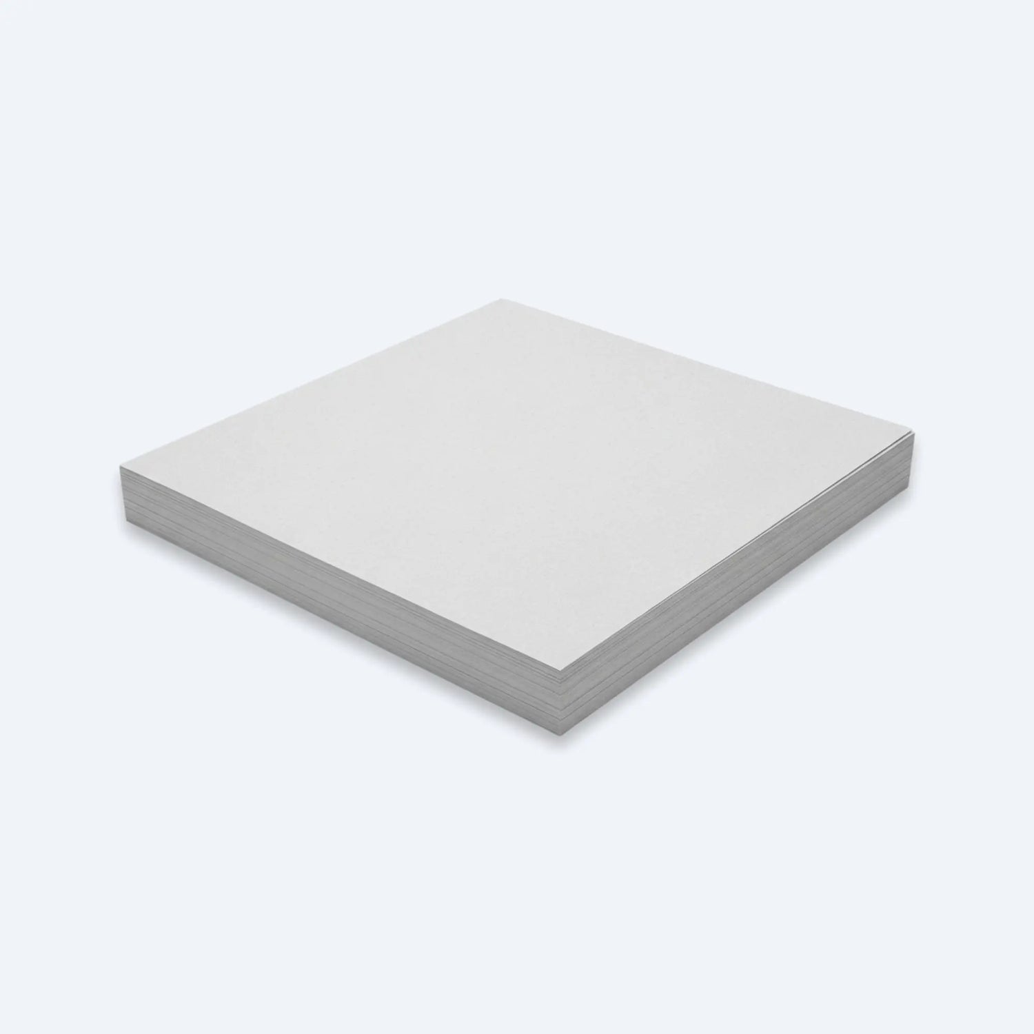 Low stack of unprinted newsprint paper sheets neatly squared for bulk packaging use.