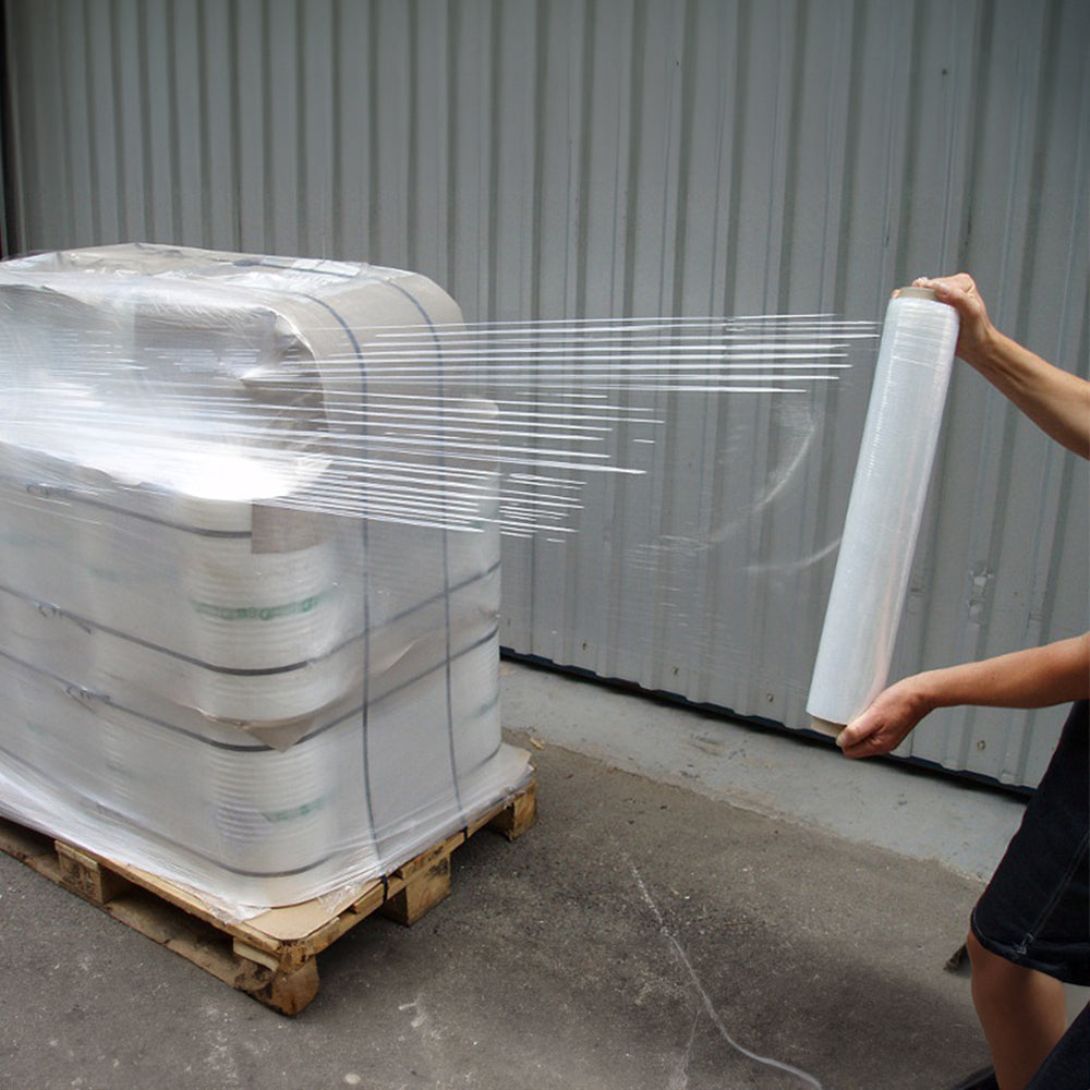 工人使用拉伸綑膜進行捆綁包裝貨物，是一種包裝物料，確保運輸安全，倉庫背景。