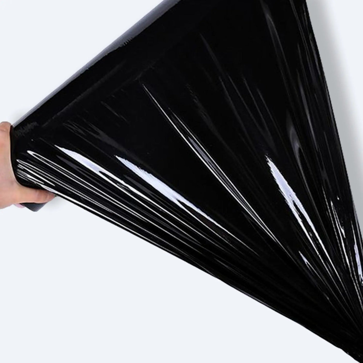 Hand stretching glossy black pallet wrap film to demonstrate elasticity