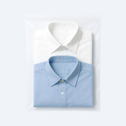 Two folded dress shirts, white and blue, neatly packed in a transparent PE flat bag for retail presentation.